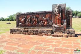 Escultura de pedra representando figuras religiosas nas ruínas de São João Batista.